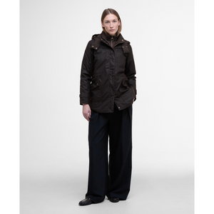 Kuvassa naisella on päällään Barbourin Cannich -öljykangastakki joka on lantiomittainen.