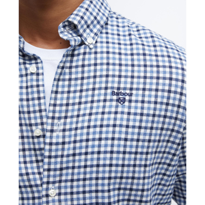 Kuvassa on klassisella gingham -ruutukuviolla ja Barbourin logolla varustettu sinivalkoruudullinen miesten kauluspaita.