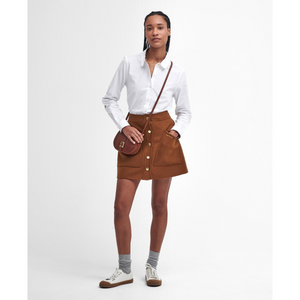 Kuvassa naisella on Barbourin klassinen valkoinen paitapusero.