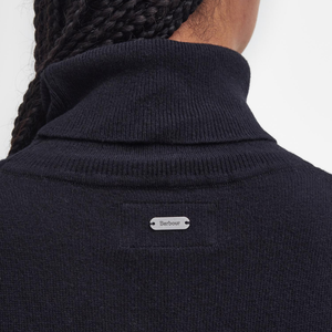 Kuvassa näkyy pieni neuleen niskaan ommeltu logolaatta.