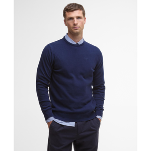 Kuvassa miehen päällä on tummansinen, klassinen villaneule pyöreällä pääntiellä.