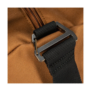 Kuvassa näkyy Carhartt Classic Round Duffel laukku joka on ruskea ja siinä on musta kantohihna.