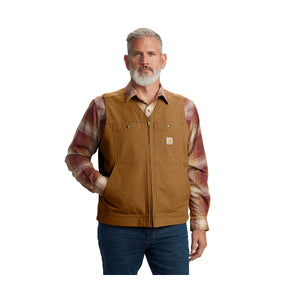 Miehellä on päällää Carhartt Montana Duck liivi. Liivissä on taskut jossa pitää käsiä.