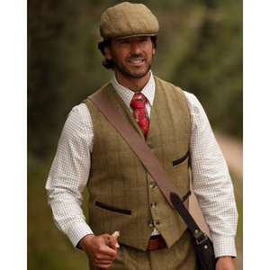 Miehen päällä on Alcott Waistcoat -tweedliivi ja saman sarjan Cambridge Flat Cap.