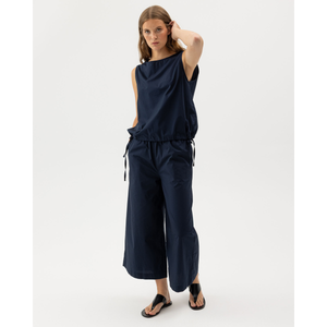 Naisella on päällä tummansiniset Holebrook Marie leveälahkeiset kesähousut.