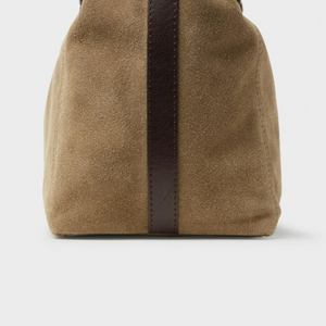 Saddler Inés Mini Tote ruskean mokkanahkalaukun pääty lähikuvassa, tummanruskea nahkainen somiste ja tikkaukset.