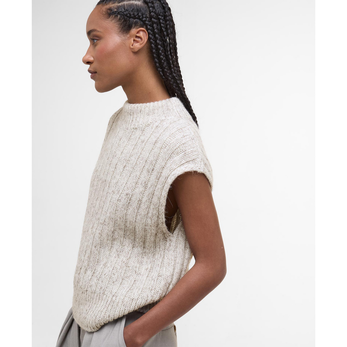 Kuvassa naisella on päällä Barbourin Anastasia neuleliivi jota voi käyttää sellaisenaan tai kerrospukeutumisessa esim. kauluspaidan päällä.