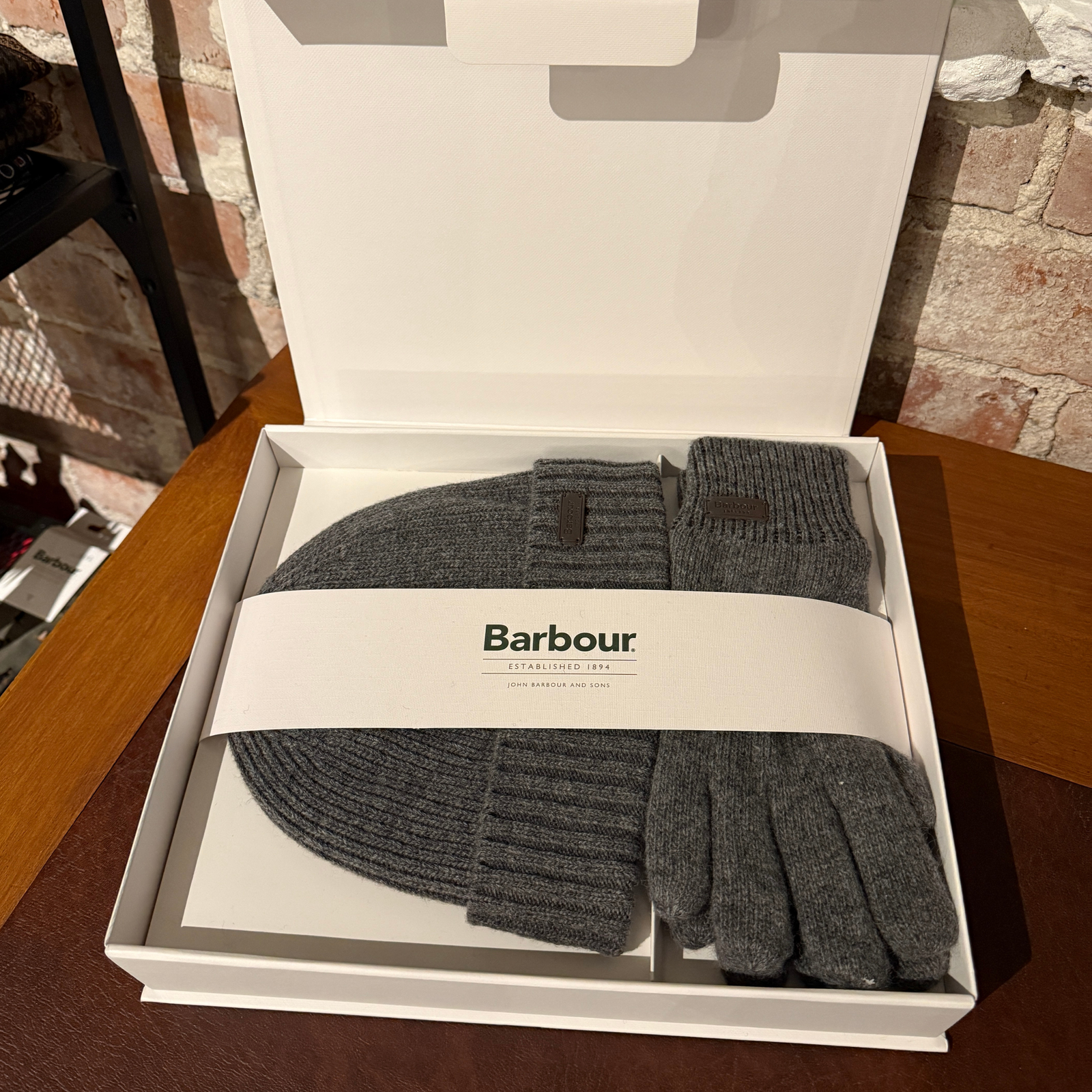 Kuvassa on Barbour Carlton lahjapakkaus jossa miesten harmaa neulepipo sekä harmaat neulesormikkaat.