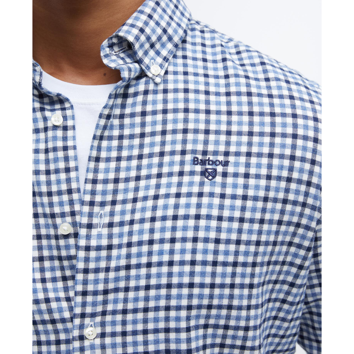 Kuvassa on klassisella gingham -ruutukuviolla ja Barbourin logolla varustettu sinivalkoruudullinen miesten kauluspaita.