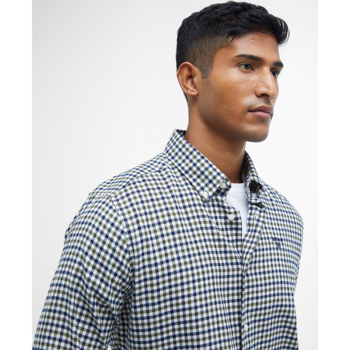 Miehen päällä on sini-vihreäruudullinen, klassinen kauluspaita.