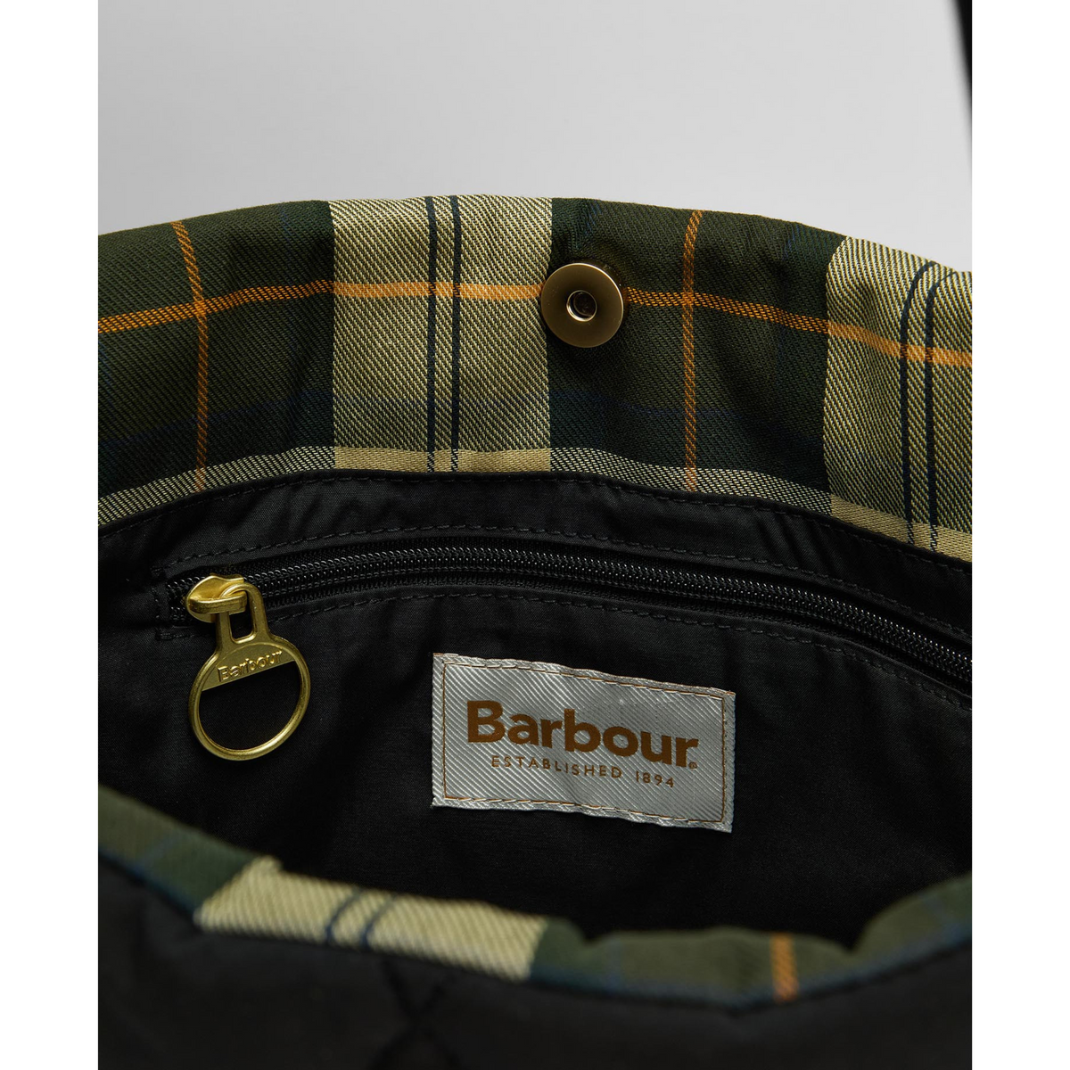 Laukussa on sisäpuolella klassista ruutukangasta ja vetoketjullinen sisätasku.