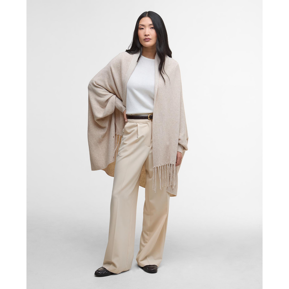 Kuvassa naisella on hiekanvärinen Tabitha -neuleviitta hihoilla.