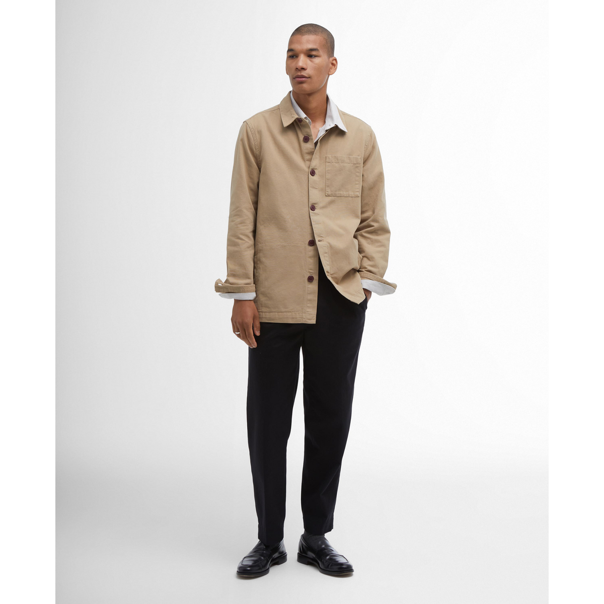 Kuvassa mies pitää päällään Barbour Washed Overshirt paitatakkia. Paitatakin hinoissa on napit, jotka saa avattua ja hihat käärittyä ylös. 