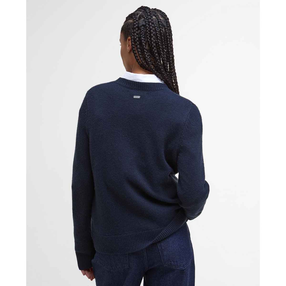 Tässä neulepaidassa on niskassa pieni metallinen logolaatta.