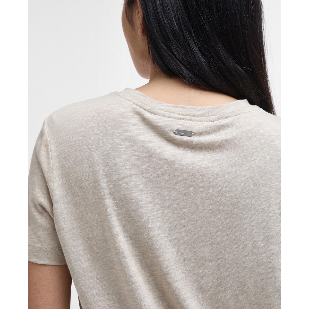 Lähikuvassa takaapäin kuvattuna Barbour Ava Top naisten t-paita. Paita on väriltään vaalean beige ja taakse on ommeltu pieni Barbour merkki.