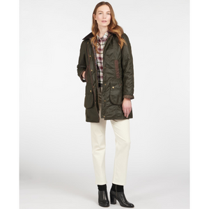 Kuvassa naisella on päällään tummanvihreä Barbour Bower Wax Jacket takki.