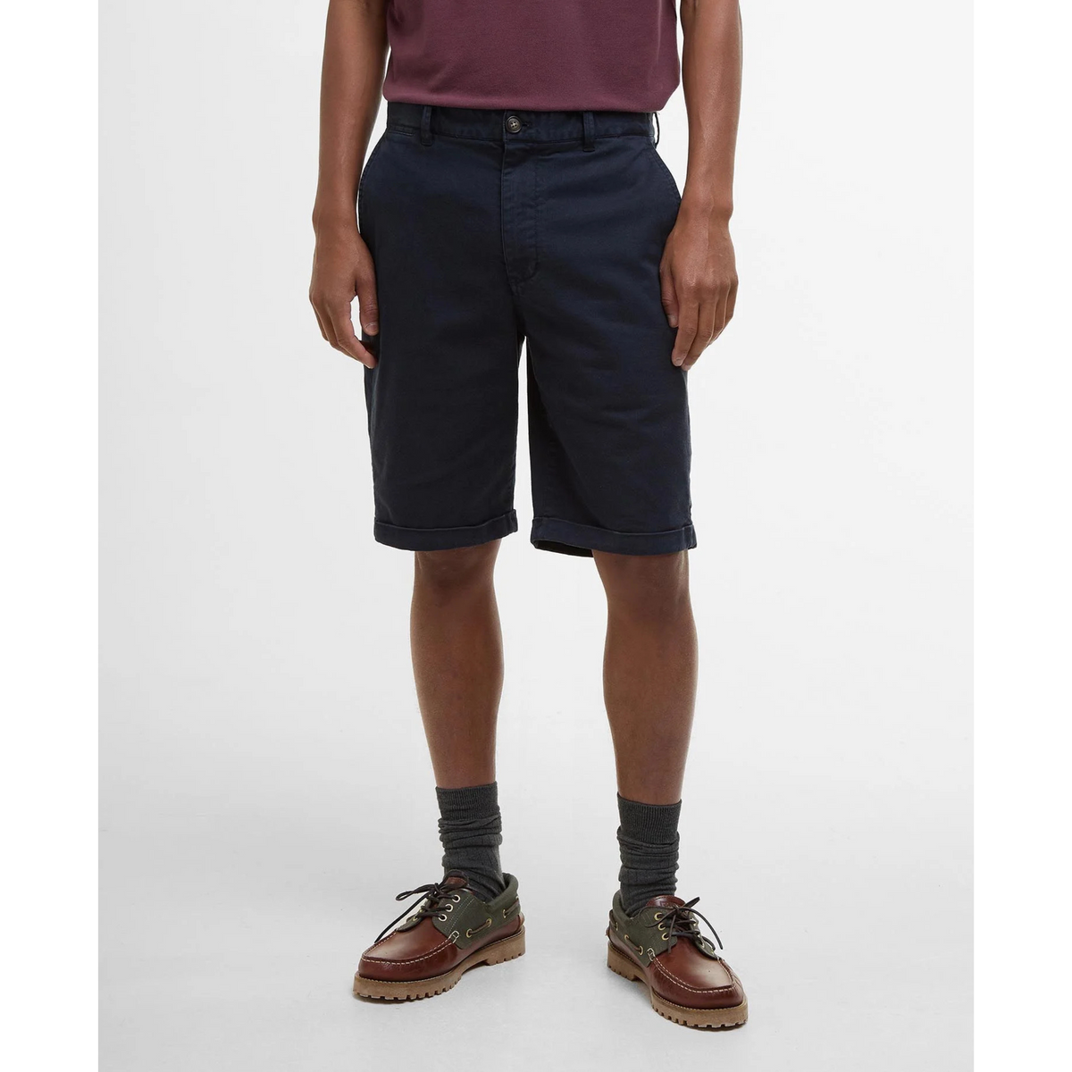 Lähikuvassa miehellä on päällä Barbour Washed Twill Chino shortsit. Housuissa on edessä taskut. 