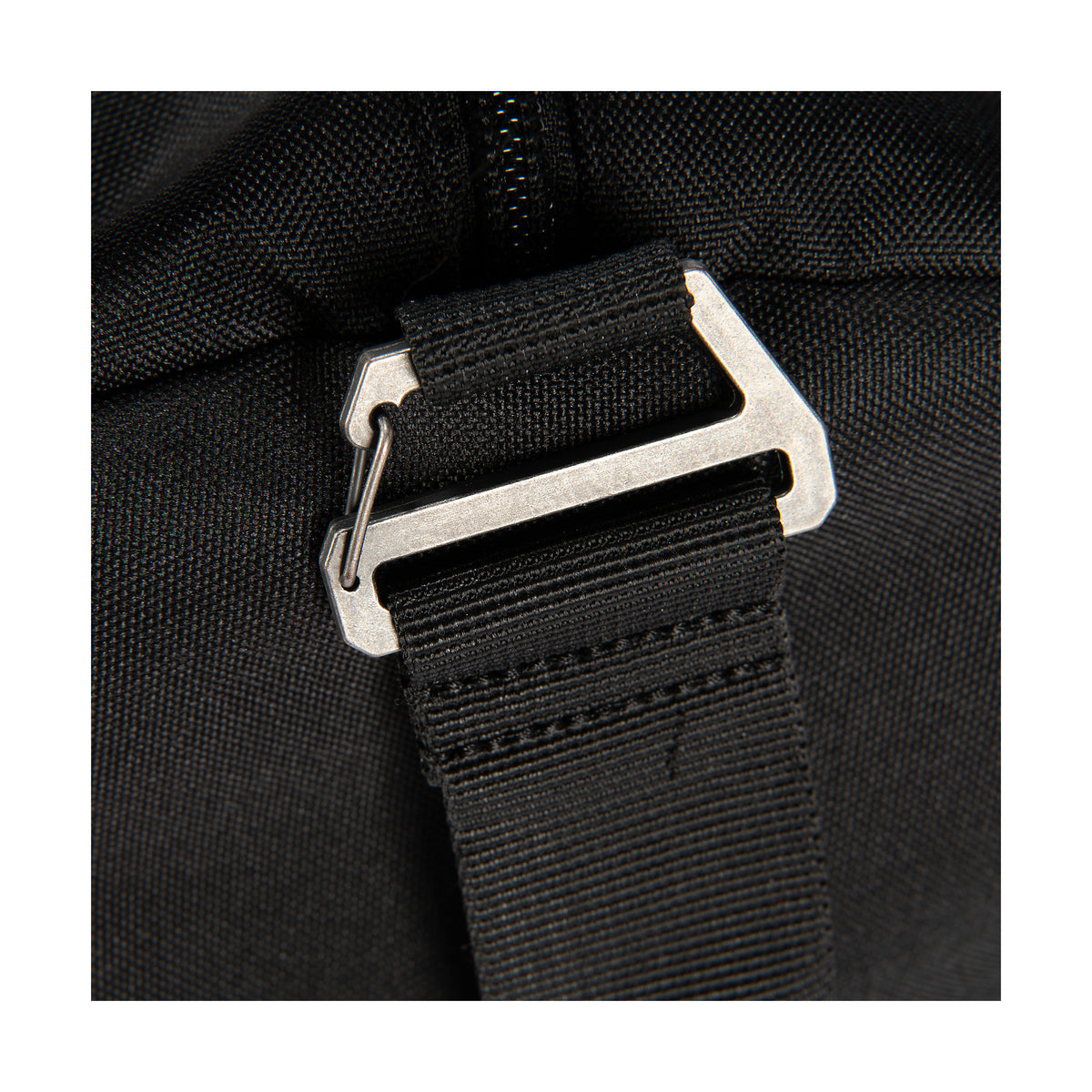 Lähikuvassa Carhartt Classic Round Duffel laukun kantohihna kiinnitys koukku jonka voi tarvittaessa irroittaa. 