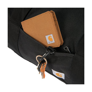 Lähikuvassa Carhartt Classic Round Duffel laukku jossa on pieni tasku vaikkapa lompakolle. Lisäksi taskussa on lenkki johon saa avaimet kiinni. 