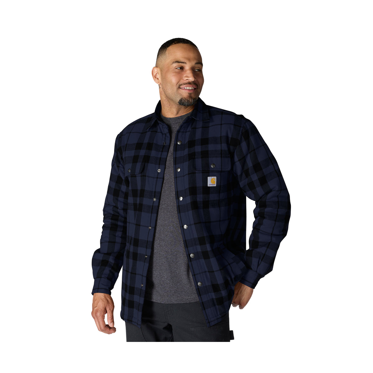 Miehellän kuvassa päällä Carhartt Flannel Sherpa Lined paitatakki jossa sulkemiseen tarkoitetut napit. 