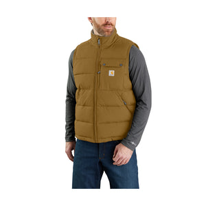 Kuvassa miehen päällä on ruskea Carhartt Montana toppaliivi jossa on rinnassa suuri läpällinen neppareilla suljettava tasku sekä piilotasku jossa on vetoketju.