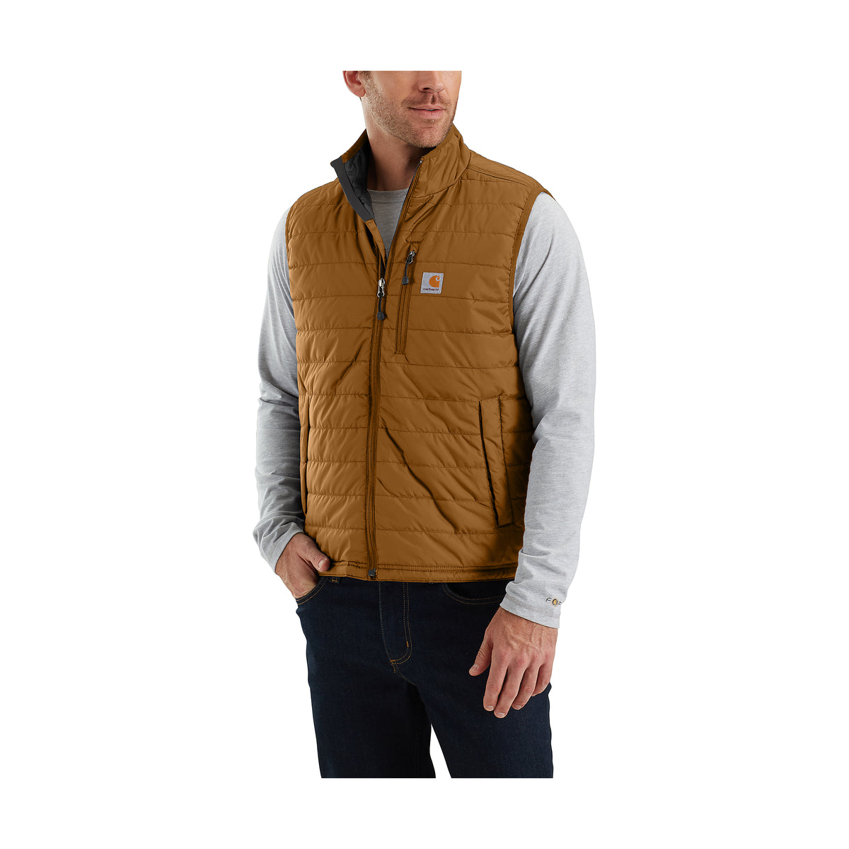Miehellä on kuvassa päällä Carhartt Rain Defender LW Insulated Vest liivi jossa on rinnassa Carhartt logo. Liivissä on ohut vettähylkivä tikkikangas.