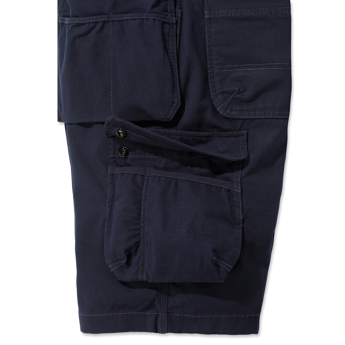 Sivusta kuvattuna Carhartt Steel Multipocket shortsit jossa on reisitasku jonka voi sulkea napeilla. 