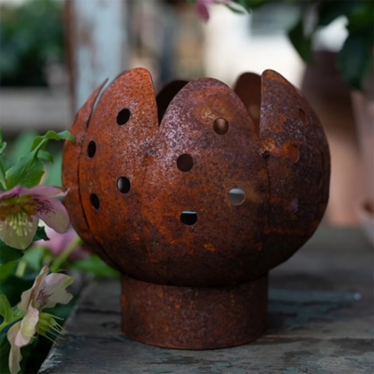 Kuvassa on ruosteisesta metallista valmistettu tulppaanin mallinen ulkotuliteline.