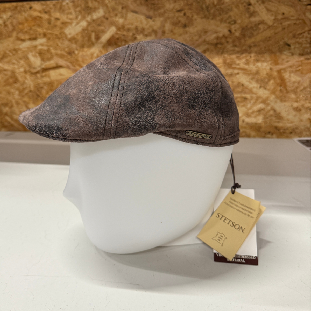 Kuvassa on ruskea nahkainen, vintagekäsitelty Gatsby -mallinen hattu.