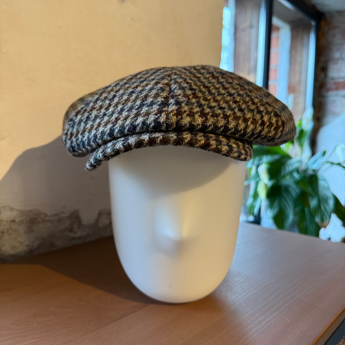 Hatussa on kaareva lippa ja hatun muoto on runsas ja pyöreä.