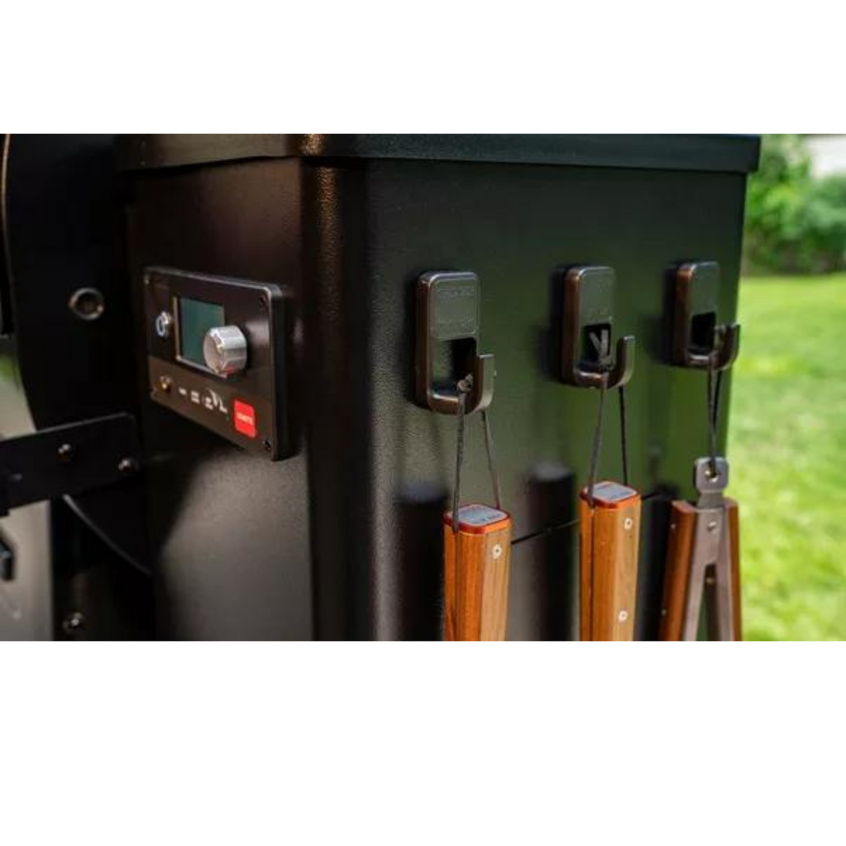 Kuvassa Traeger magneettikoukut grillaustyövälineille kiinnitettynä grillin kylkeen.