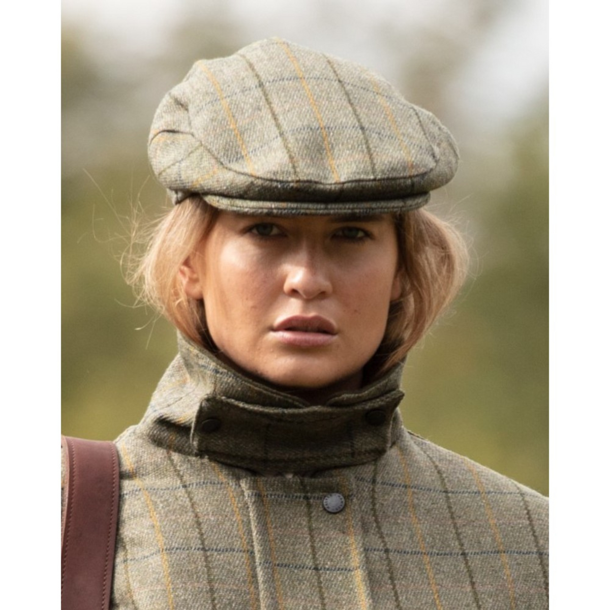 Kuvassa naisella on päässä Walker Hawkesin Derby Tweed Cambridge Flat Cap Navy Stripe.