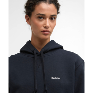 Lähikuvassa mallin päällä tummansininen Barbour Bede huppari jonka vasemmassa rinnassa on valkoinen logokirjailu.