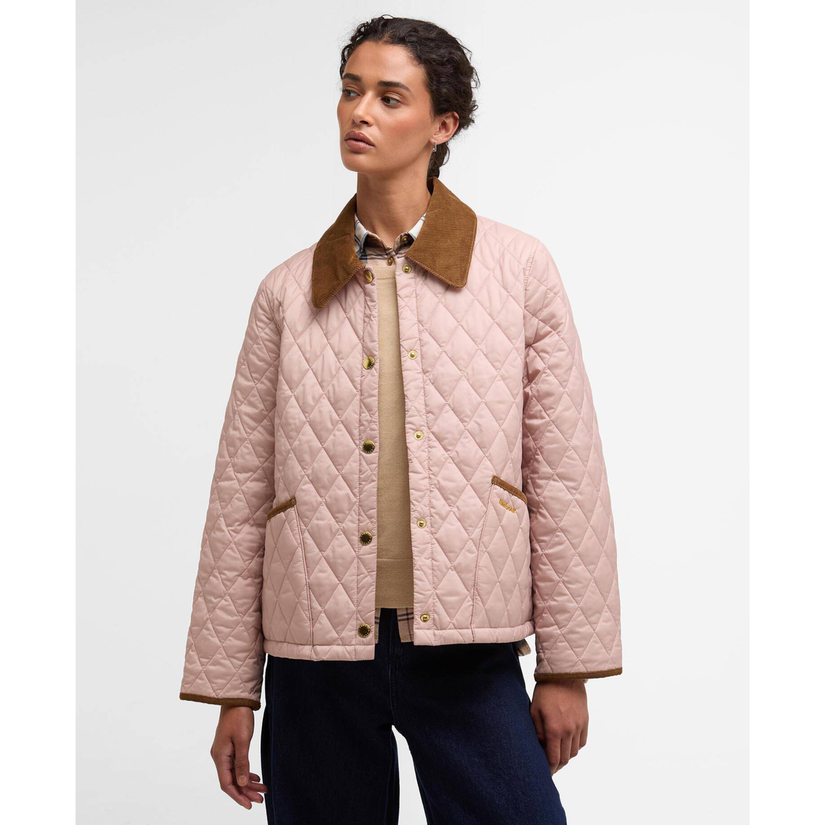 Naisella on päällään vaaleanpunainen Barbour Icons Cropped Liddesdale takki ja tummansiniset housut.