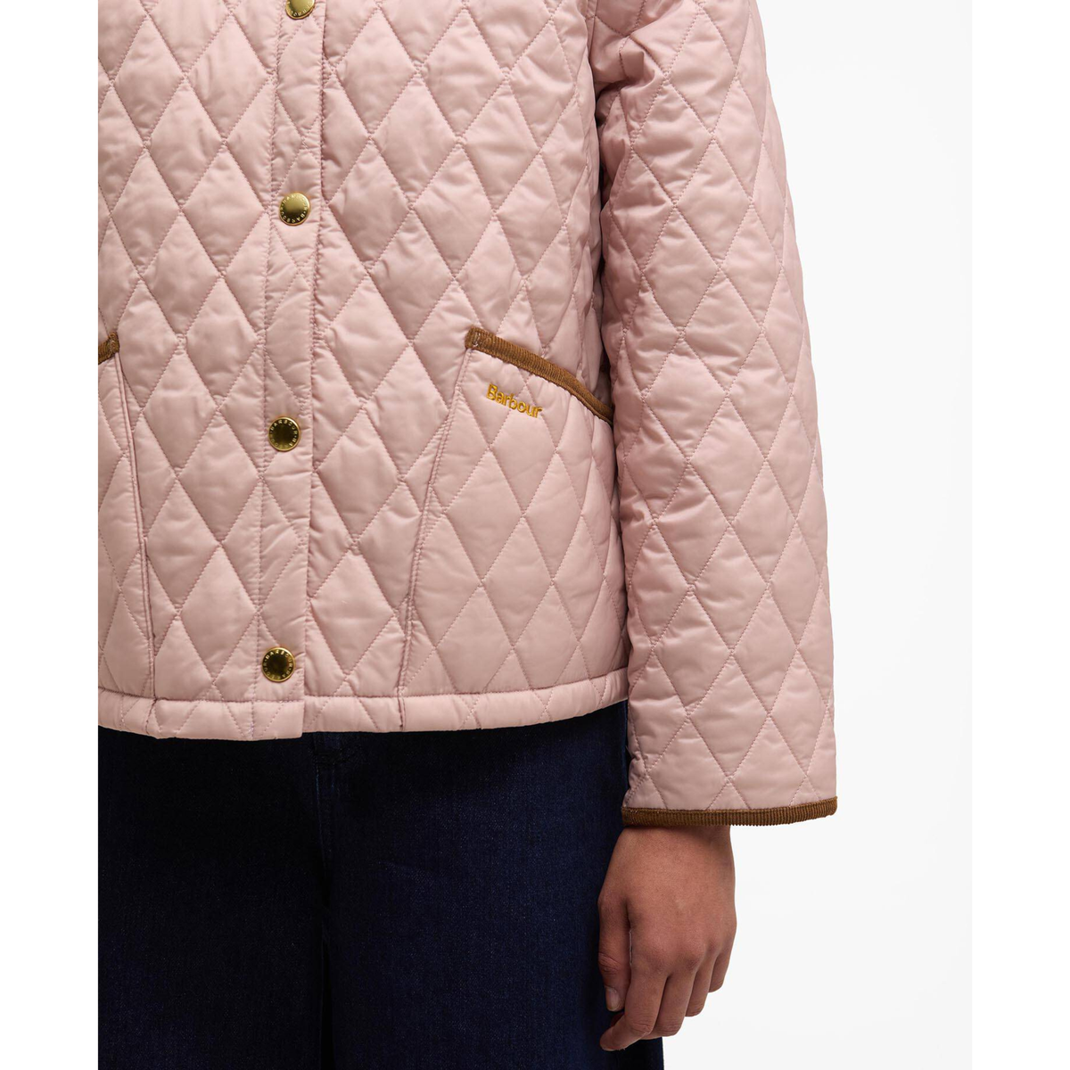 Lähikuva takin vasemmasta taskusta jossa on ruskea samettireunus ja kirjailtu Barbour logo.