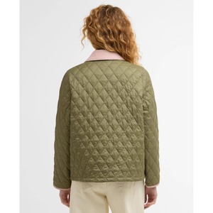 Naisen päällä vaaleanvihreä Barbour Icons Cropped Liddesdale takki kuvattuna takaapäin.