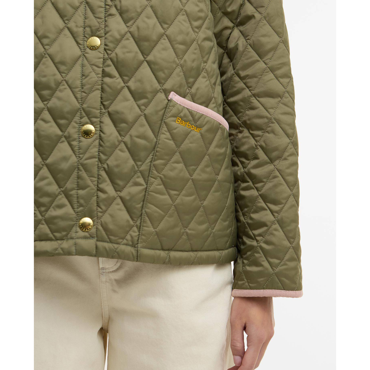 Lähikuva takin vasemmasta etutaskusta johon on brodeerattu Barbour -logo.