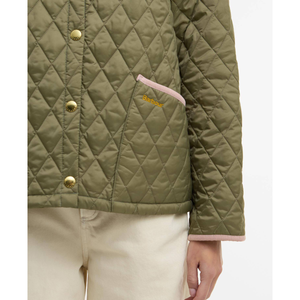 Lähikuva takin vasemmasta etutaskusta johon on brodeerattu Barbour -logo.