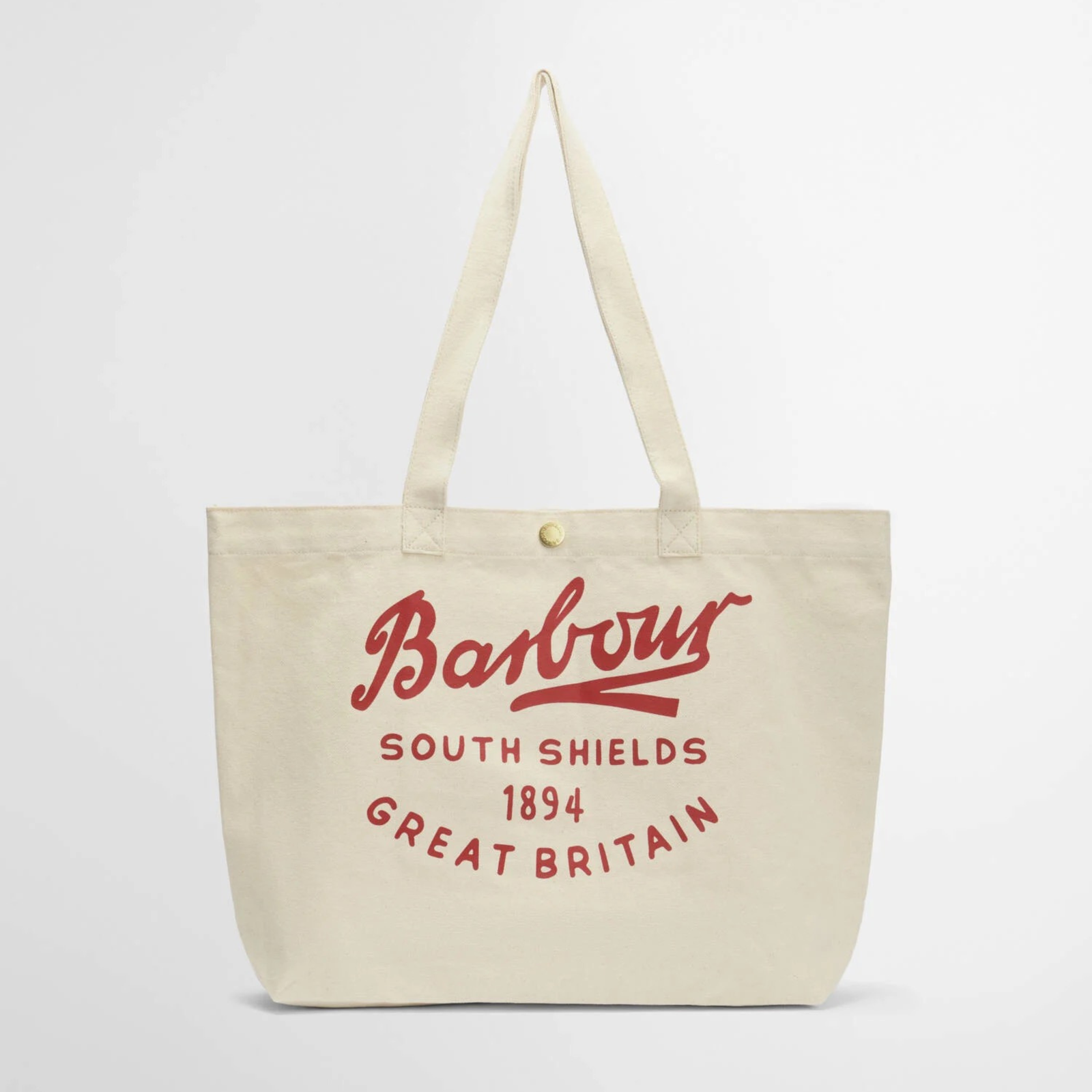 Barbour Script Tote kangaskassissa on punainen näyttävä logo kassin sivussa. Kassissa on nepparikiinnitys.
