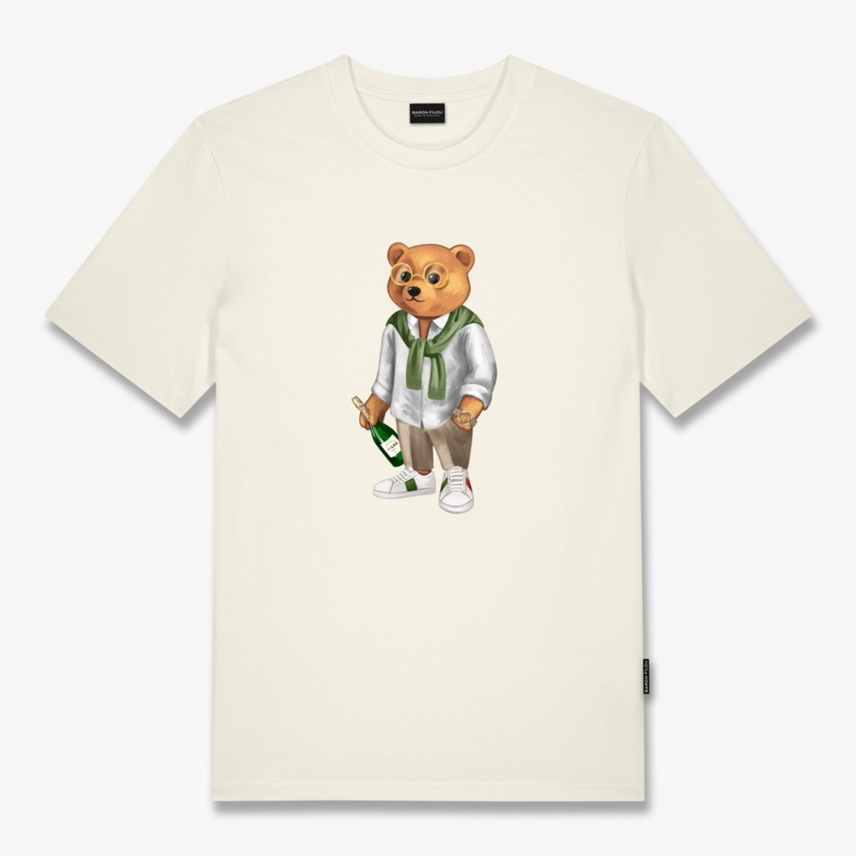 Kuvassa on valkoinen Baron Filou merkkinen t-paita. Paidassa on nalle jolla on shampanjapullo kädessä. 