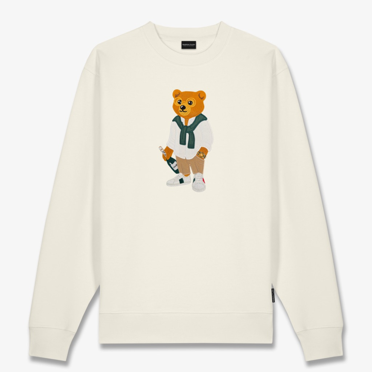 Kuvassa on valkoinen Baron Filou collegepaita jossa Filou nallella on kädessä shampanjapullo. 