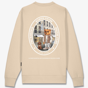 Kuvassa on beige Baron Filou collegepaita jonka takana on kuva Filou nallesta ulkona koiran kanssa. 