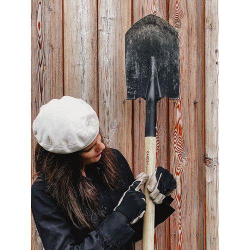 Kuvassa on nainen, joka pitää kädessään By Benson puutarhalapiota.