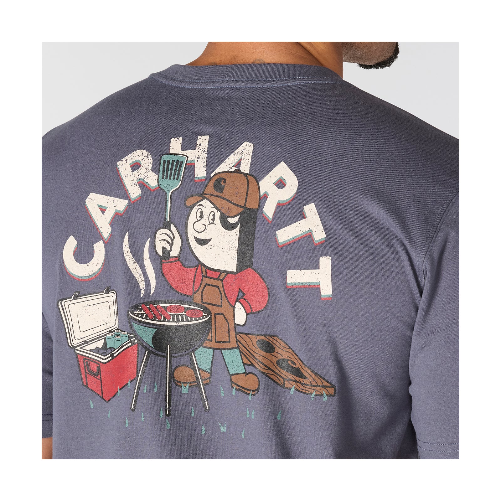 Carharttin t-paita, jonka selässä olevassa kuvassa on piirroshahmo grillaamassa.
