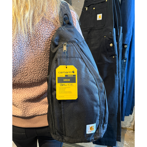 Musta tilava Carharttin Sling Back -reppu naismallin olkapäällä.