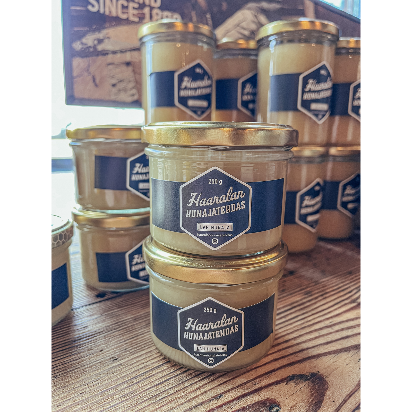 Kuvassa on pöydällä Haaralan Hunajatehtaan lähihunajaa 250g:n lasipurkeissa.  
