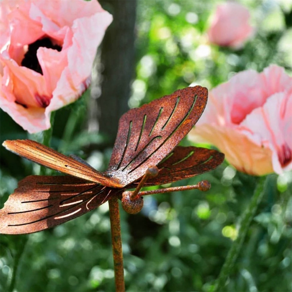 Kuvassa on puutarhaan sopiva metallinen, ruosteinen koristeperhonen.