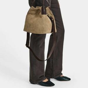 Saddler Inés Mini Tote ruskea mokkanahkainen käsilaukku mallin käsivarrella, pitkä nahkainen olkahihna vapaana.