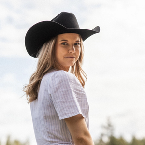 Kuvassa naismallilla on päässään musta Salon Lakkitehtaan Cowboy -hattu.